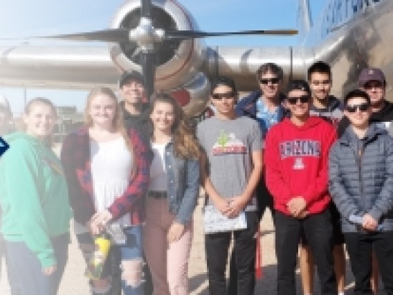 Group photo in front of a plane